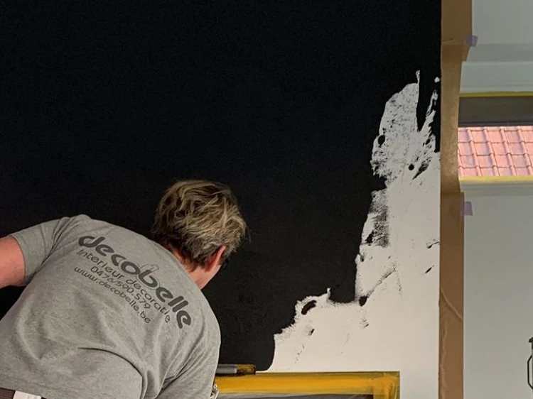 Isabelle werkt een diepzwarte wand af rond een goudkleurige lijst